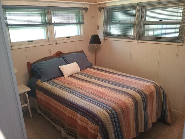 a bedroom with a bed and a large window