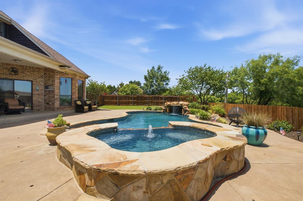 600 Aspen Street Pilot Point, TX 76258 - Photo 32 of 39 Curved pool and spa featuring stone coping and a waterfall rock formation