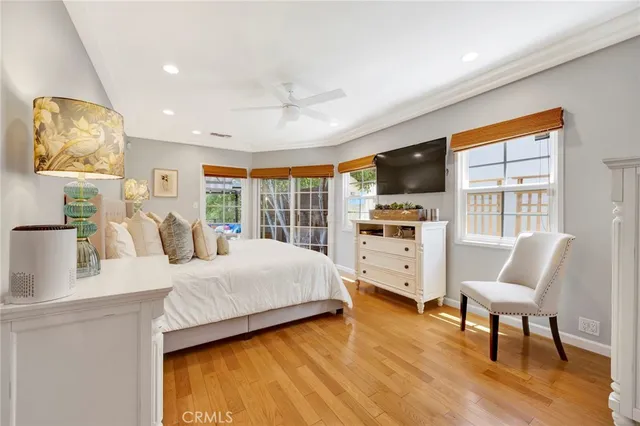 a spacious bedroom with a large bed and a flat tv screen