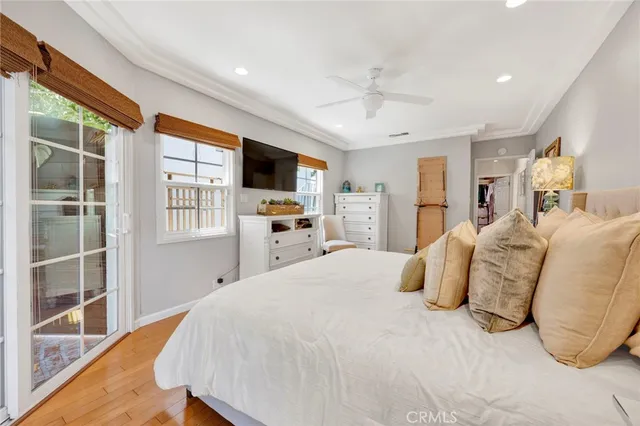 a bedroom with a large bed and a flat tv screen on dresser