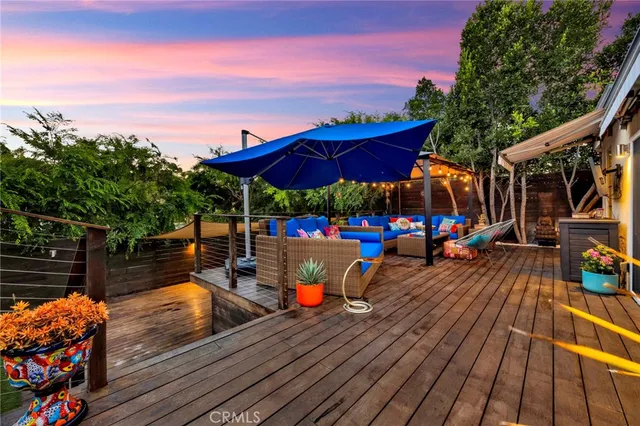 a view of a roof deck with dining table and chairs with wooden floor