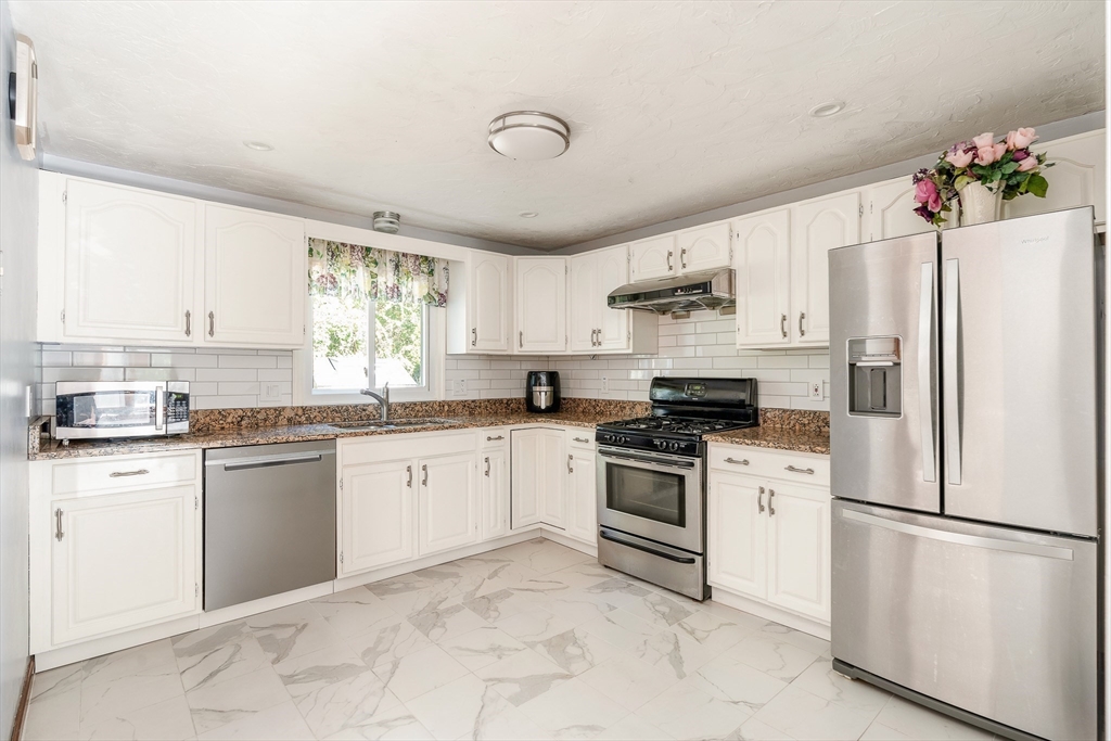 12 Loyola Circle Boston, MA 02132 - Photo 5 of 29 a kitchen with granite countertop white cabinets and white appliances