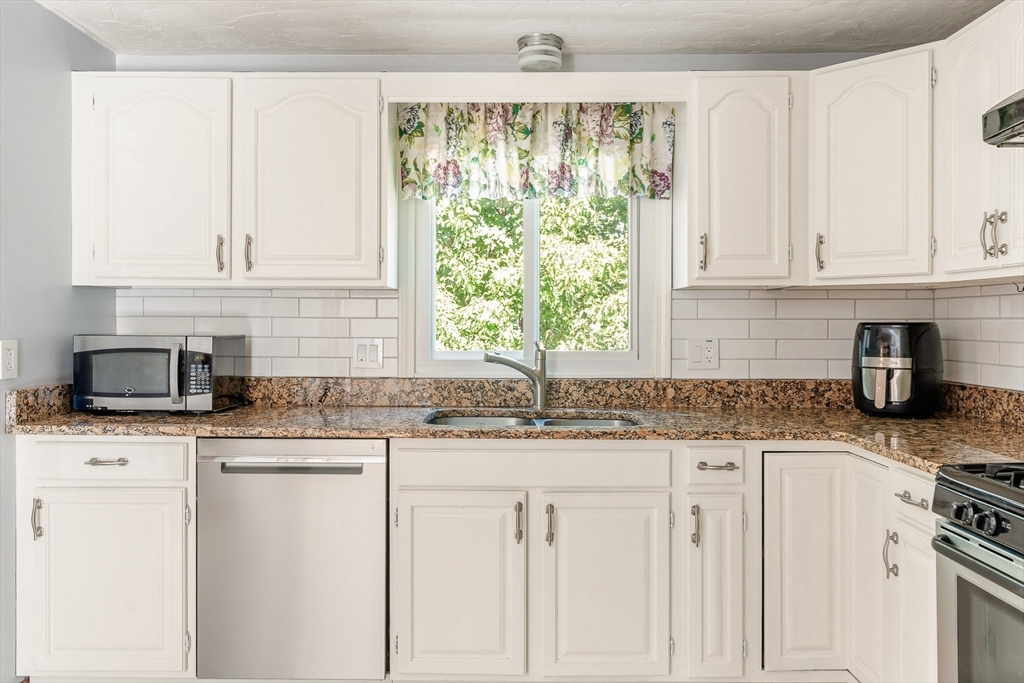 12 Loyola Circle Boston, MA 02132 - Photo 6 of 29 a kitchen with granite countertop white cabinets and white appliances