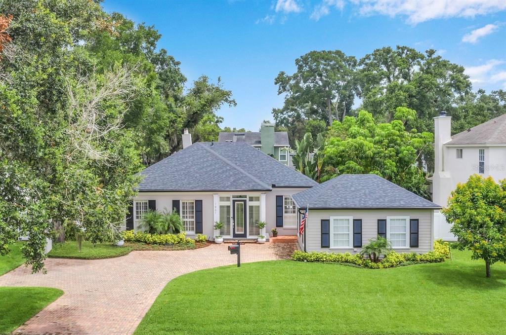 a front view of a house with a yard and trees
