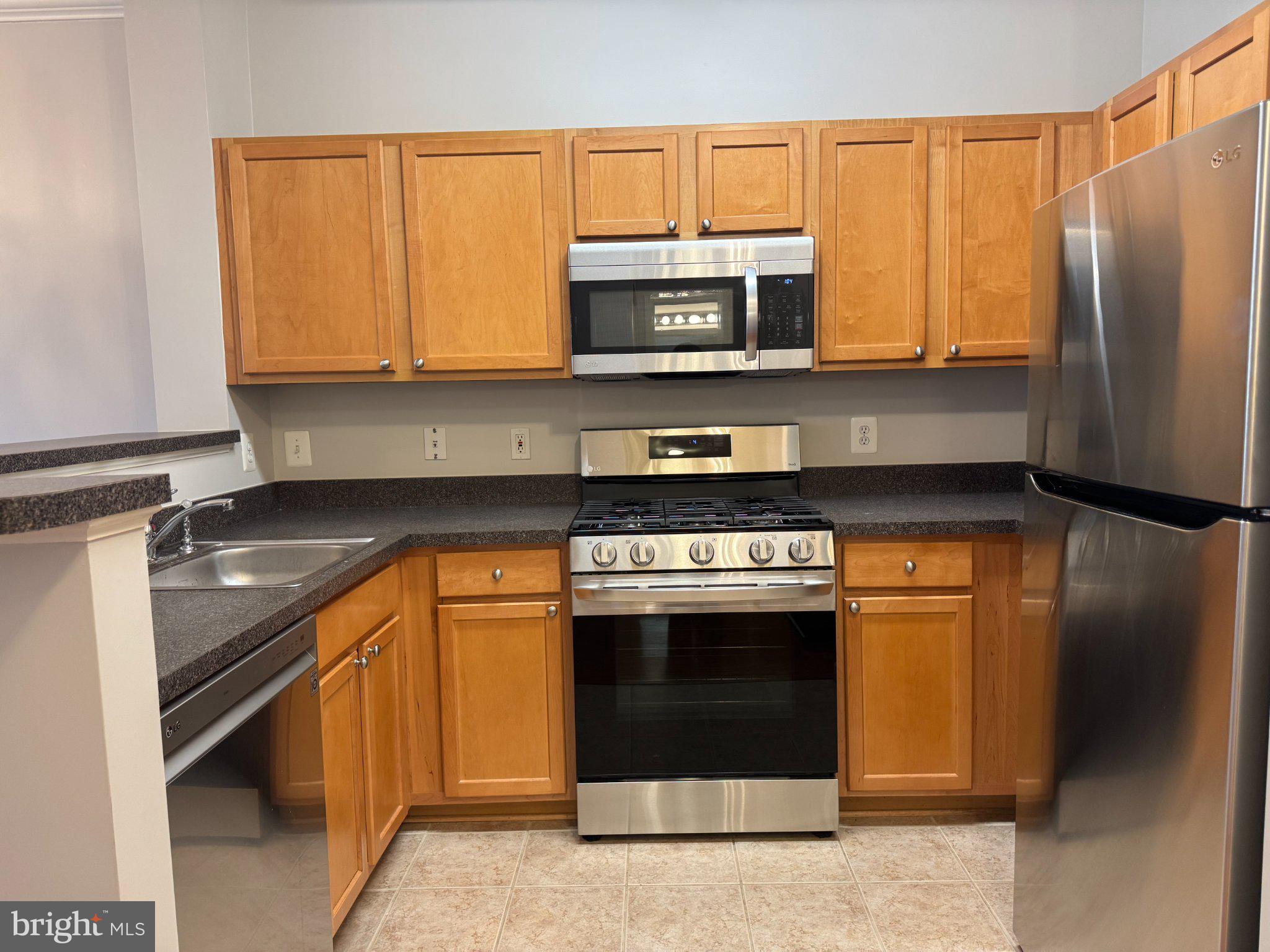 12000 Market Street, Unit 173 Reston, VA 20190 - Photo 6 of 47 Modern kitchen with warm wood tones.