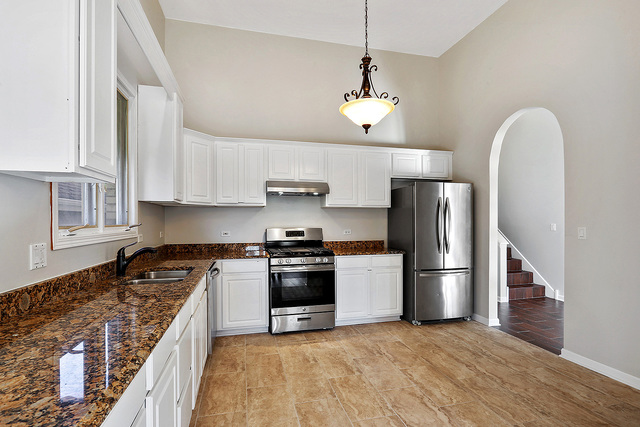 5338 State Road Burbank, IL 60459 - Photo 6 of 21 a kitchen with stainless steel appliances granite countertop a refrigerator a stove a sink dishwasher a refrigerator white cabinets and wooden floor