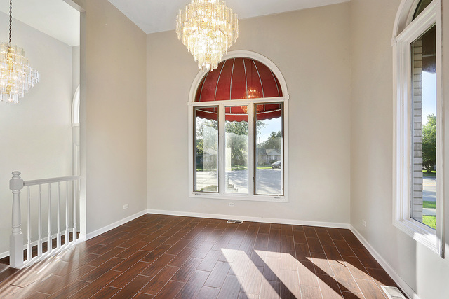 5338 State Road Burbank, IL 60459 - Photo 7 of 21 an empty room with wooden floor fan and windows