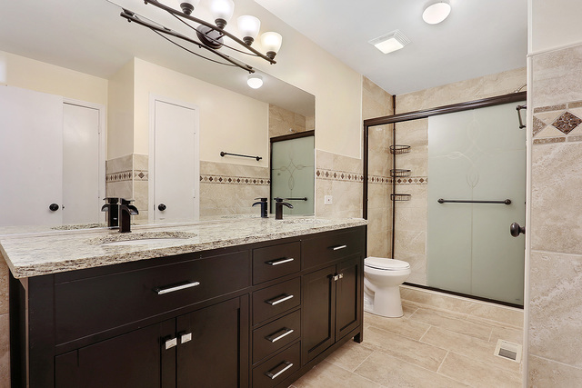 5338 State Road Burbank, IL 60459 - Photo 10 of 21 a bathroom with a granite countertop sink a toilet a mirror and shower