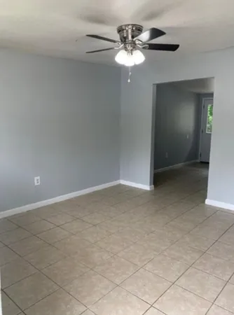 a view of an empty room with a chandelier fan