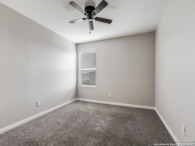 a view of a room with a ceiling fan and closet area
