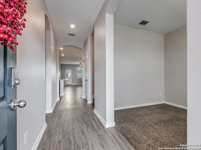 a view of a hallway with wooden floor and a potted plant