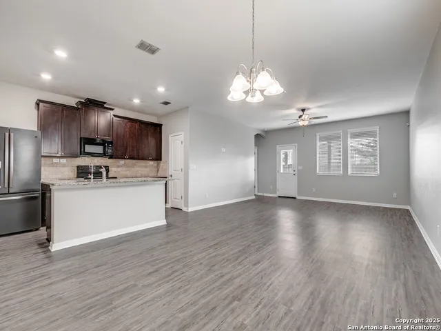 a view of a kitchen with a sink a refrigerator and a stove top oven