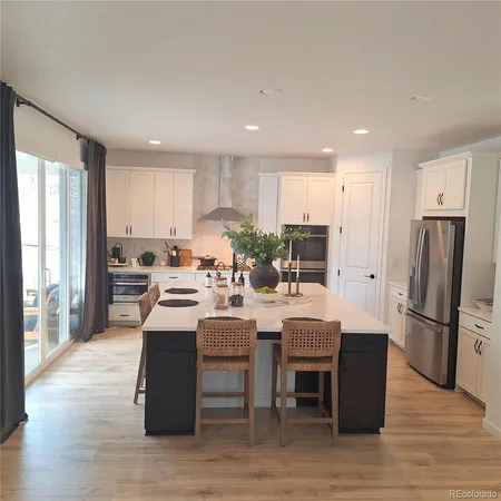 a kitchen with a table chairs refrigerator and cabinets