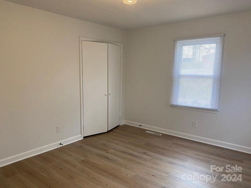 181 Spring Garden Avenue Kannapolis, NC 28081 - Photo 12 of 30 an empty room with wooden floor and windows
