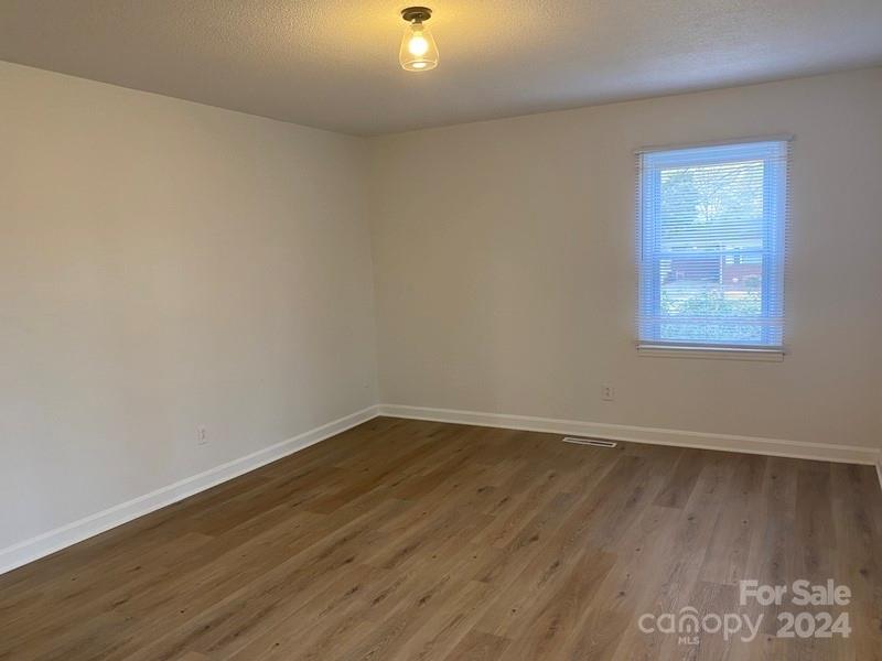 181 Spring Garden Avenue Kannapolis, NC 28081 - Photo 20 of 30 an empty room with wooden floor and windows