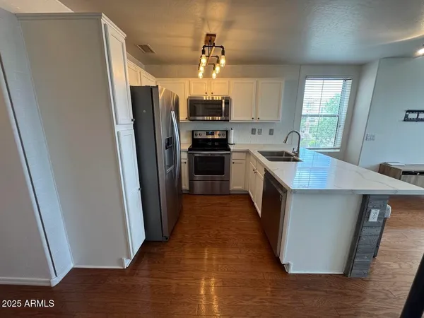 a kitchen with granite countertop a refrigerator and a sink