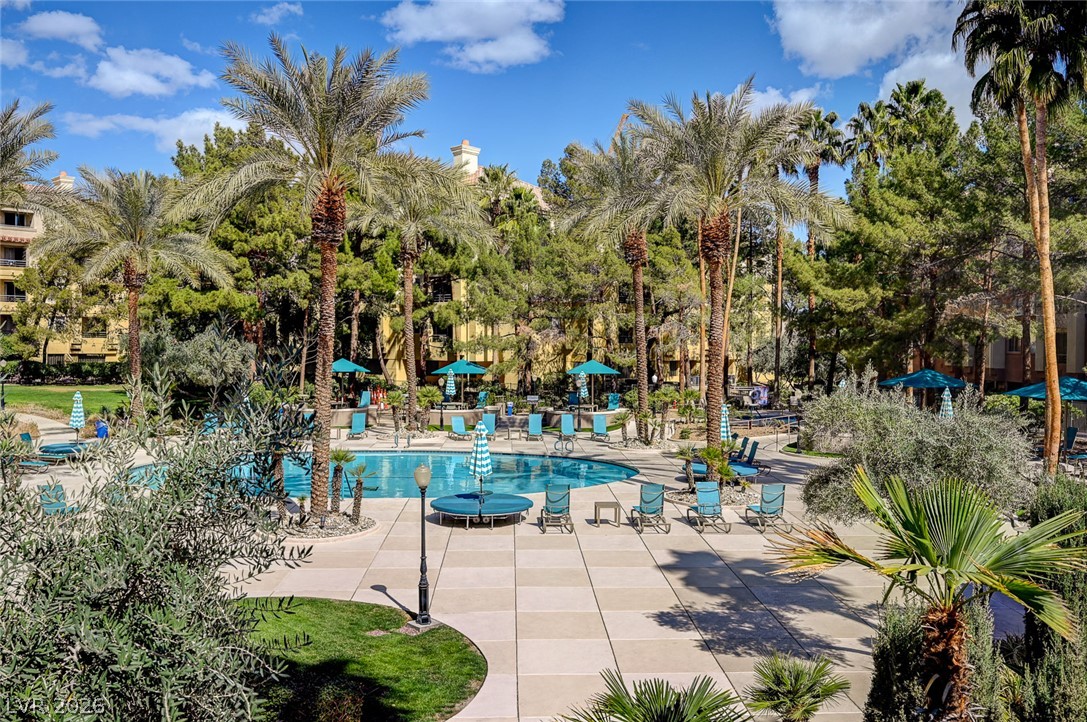 230 East Flamingo Road, Unit 106 Las Vegas, NV 89169 - Photo 40 of 66 A tranquil community pool area is surrounded by swaying palm trees and lush greenery.