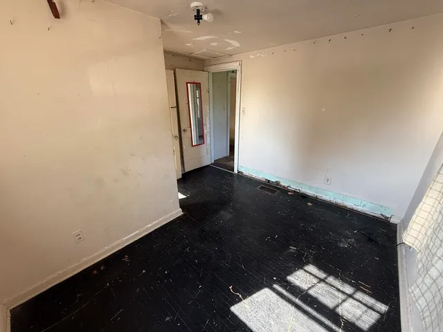 a view of an empty room and wooden floor