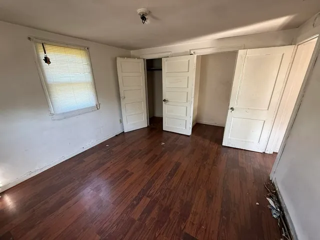 an empty room with wooden floor and closet