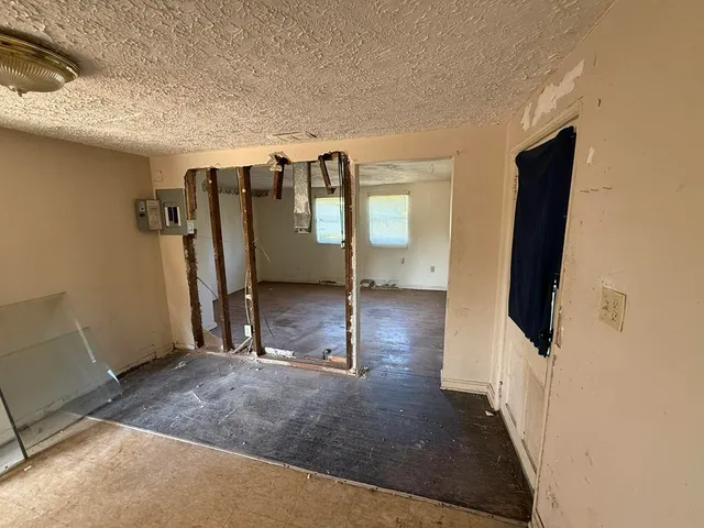 a view of a livingroom with wooden floor and a ceiling fan