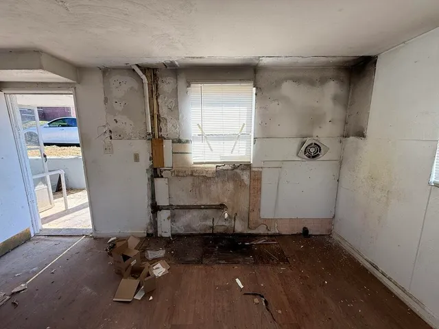 a room with water heater and a wooden door
