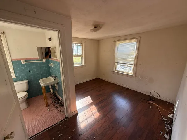 a view of living room and bathroom with wooden floor
