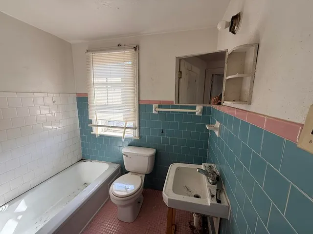 a bathroom with a toilet sink and mirror