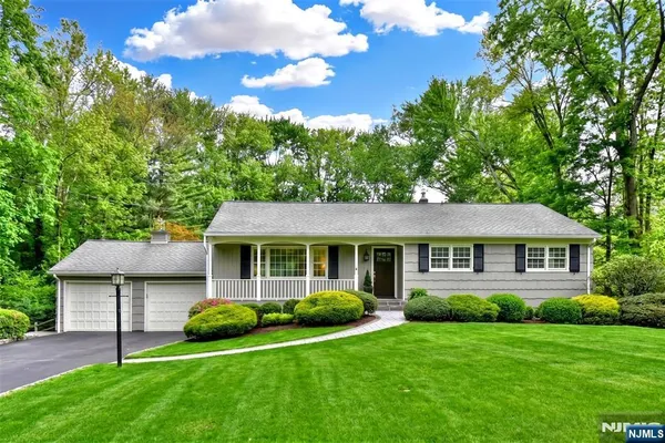 a front view of a house with a yard and green space