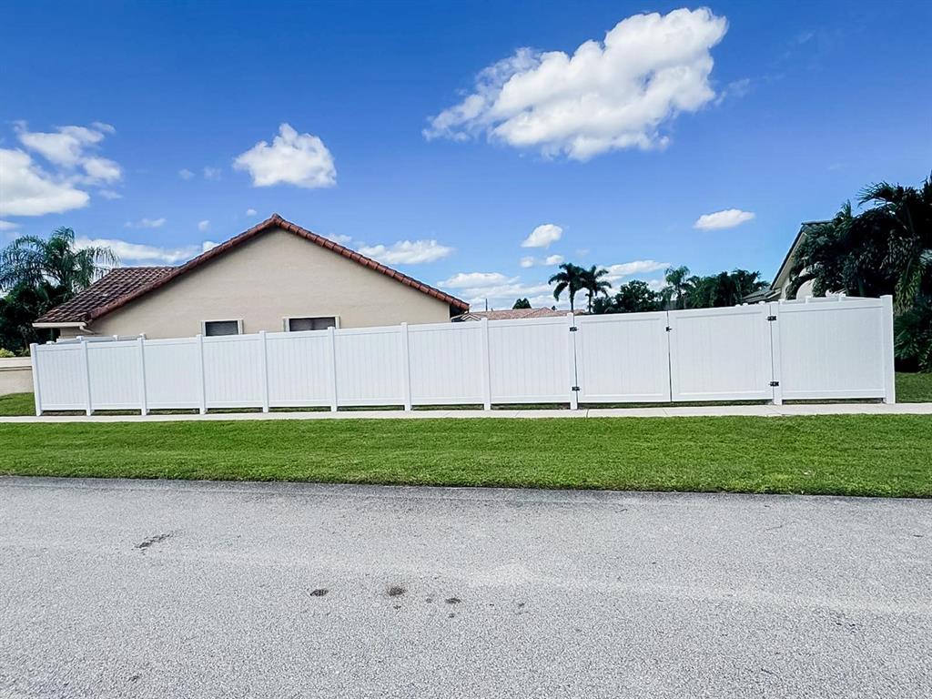 9398 Laurel Green Drive Boynton Beach, FL 33437 - Photo 15 of 19 a view of a backyard with grass and a garage