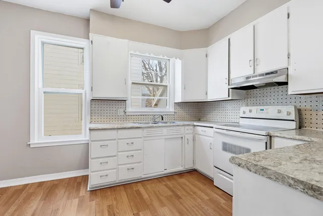 a kitchen with granite countertop white cabinets and white appliances