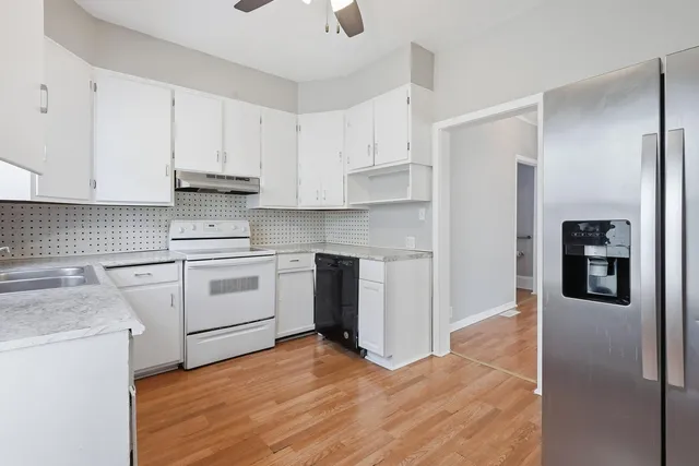a kitchen with white cabinets and stainless steel appliances