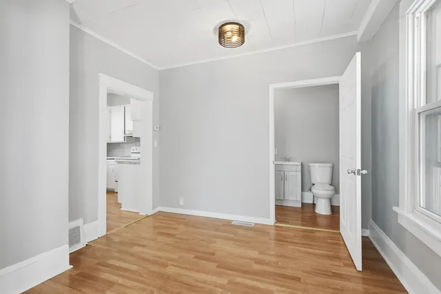 a view of empty room with wooden floor