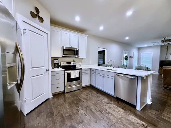 a large kitchen with stainless steel appliances sink a microwave and cabinets