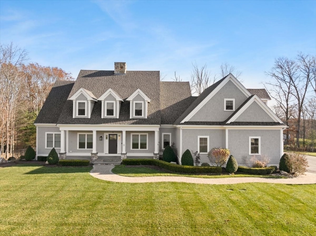 a front view of a house with a yard outdoor seating and garage