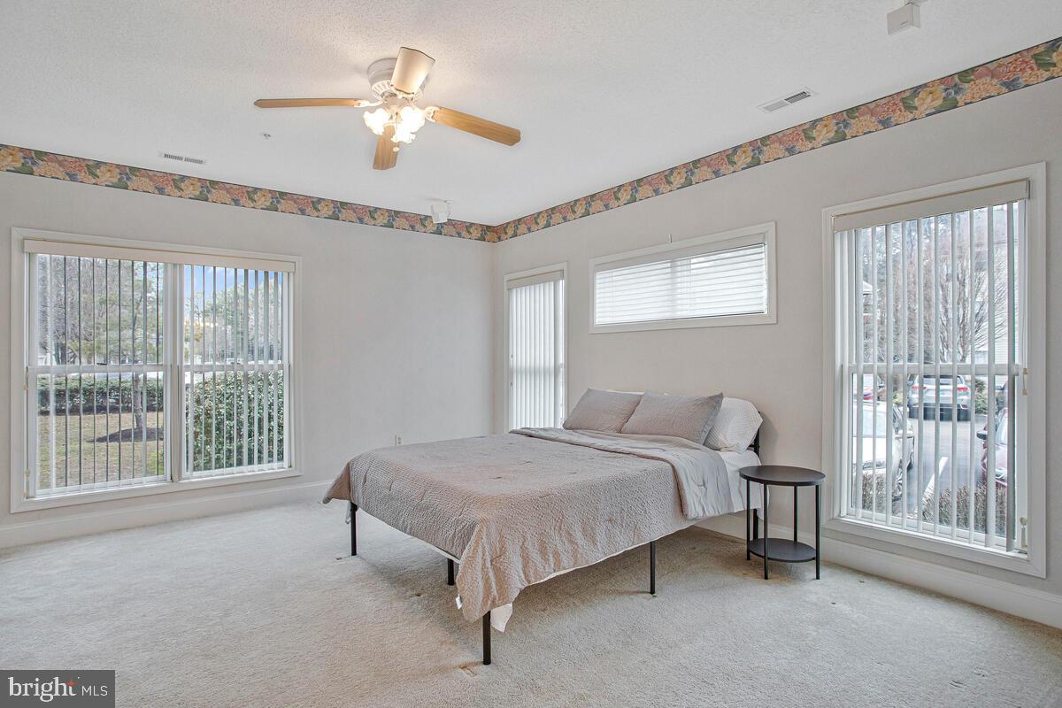 501 Runabout Loop, Unit 501 Solomons, MD 20688 - Photo 21 of 36 a bedroom with a bed and a chandelier