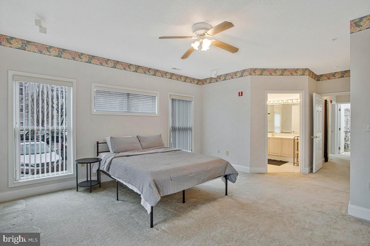 501 Runabout Loop, Unit 501 Solomons, MD 20688 - Photo 22 of 36 a spacious bedroom with a bed and a chandelier