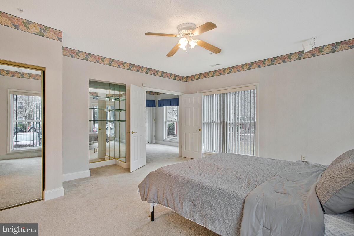 501 Runabout Loop, Unit 501 Solomons, MD 20688 - Photo 23 of 36 a bedroom with a large bed and a chandelier