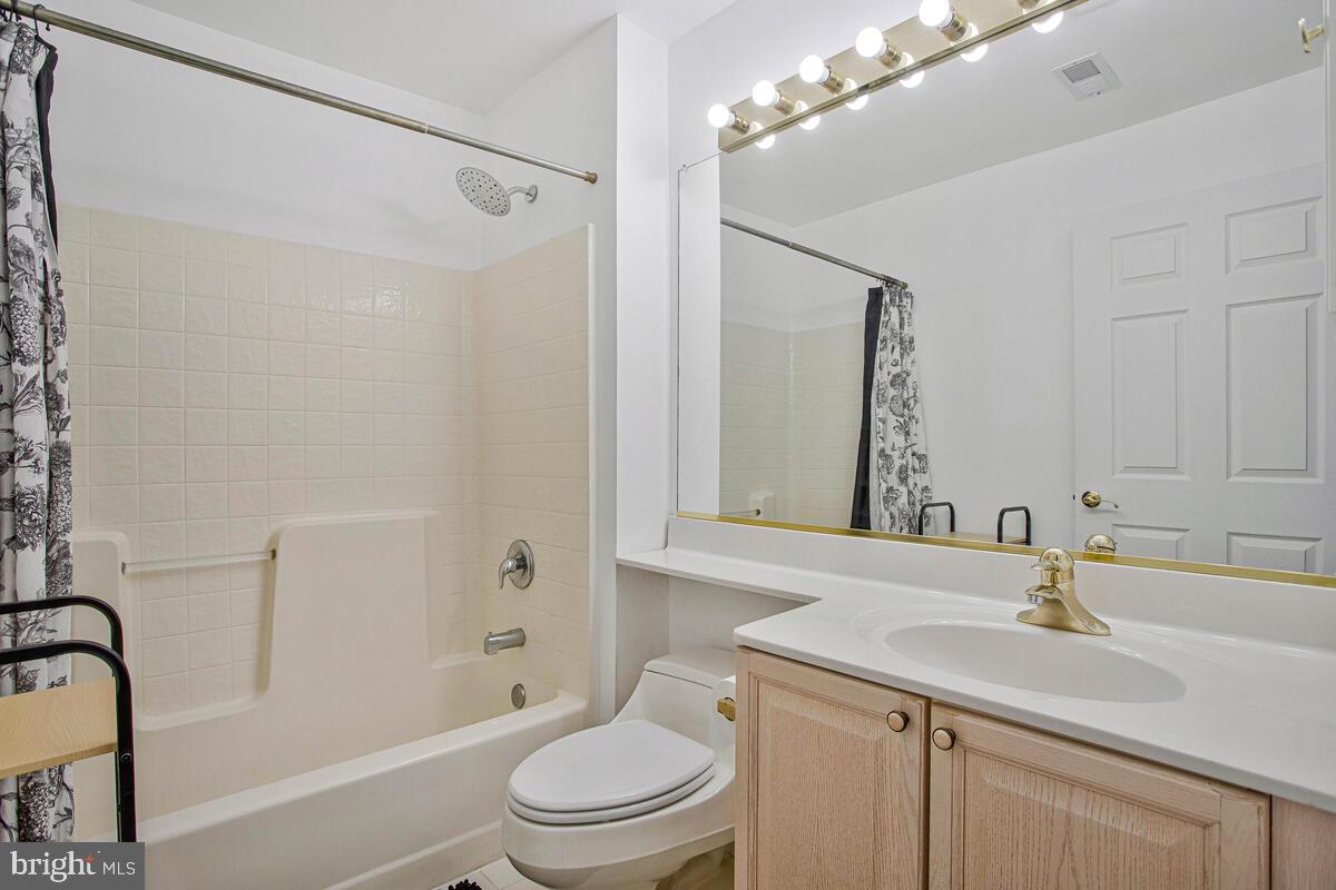 501 Runabout Loop, Unit 501 Solomons, MD 20688 - Photo 28 of 36 a bathroom with a sink toilet a mirror and shower