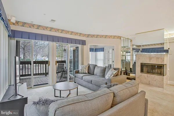 a living room with furniture a large window and a fireplace