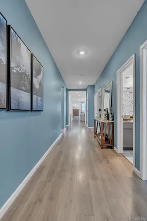a view of a hallway with wooden floor and a living room