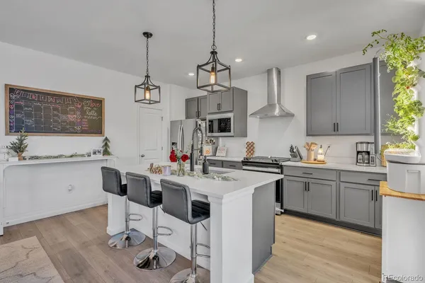 a kitchen with stainless steel appliances kitchen island granite countertop a sink stove and white cabinets