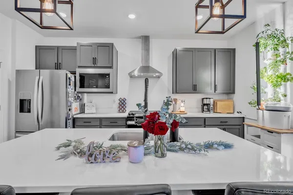 a kitchen with stainless steel appliances kitchen island granite countertop a sink refrigerator and cabinets