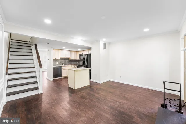 a view of a kitchen with wooden floor and electronic appliances