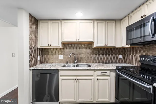 a kitchen with stainless steel appliances granite countertop a sink stove and cabinets