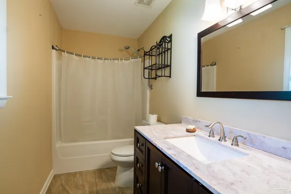 a bathroom with a granite countertop sink toilet and shower