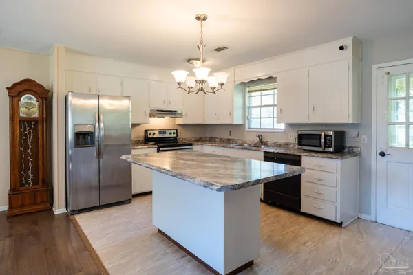 a kitchen with stainless steel appliances granite countertop a stove a refrigerator and a sink