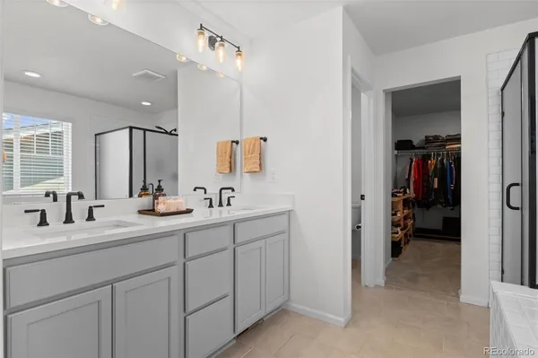 a en suite bathroom with a double vanity sink and a mirror