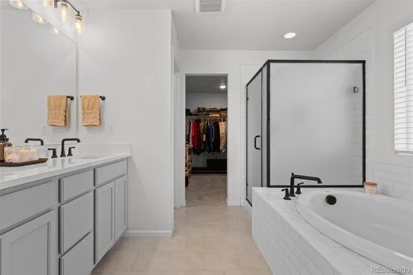 a bathroom with a tub sink and mirror