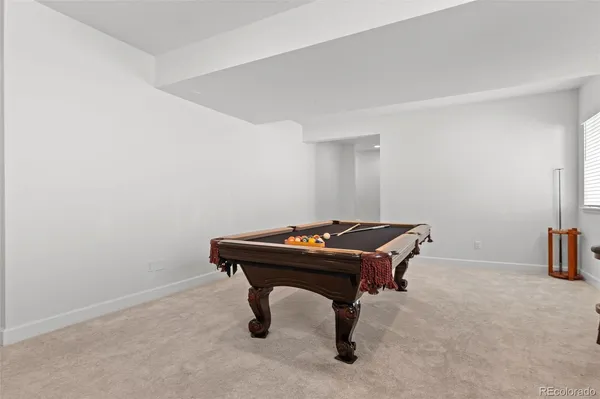 a room with furniture pool table and windows