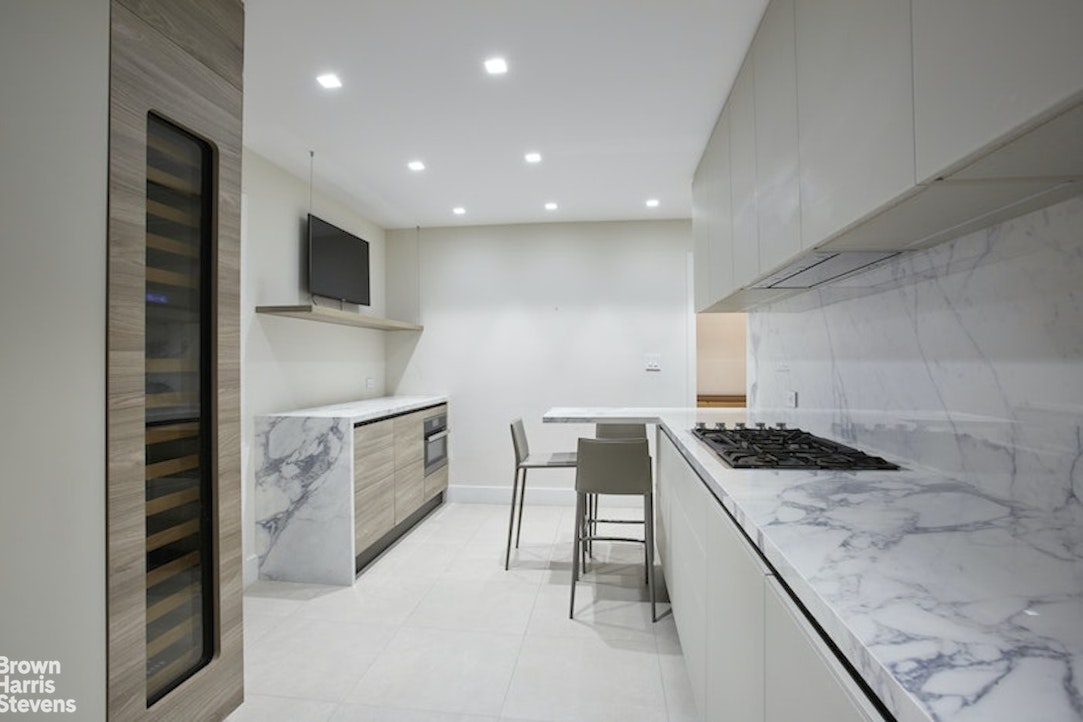 525 East 80th Street, Unit 7BC Manhattan, NY 10075 - Photo 4 of 13 a kitchen with granite countertop sink stove and cabinets